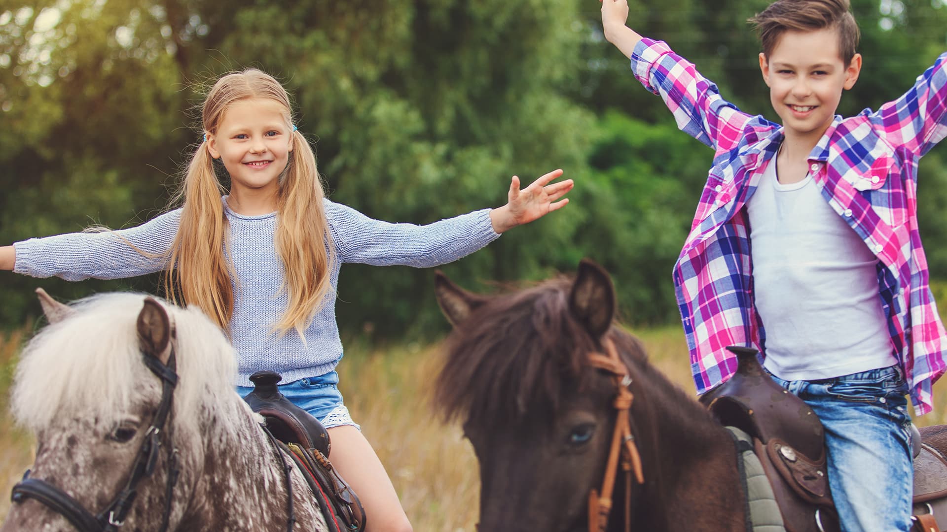 Haftpflicht - Versicherung für das Therapiepferd Kinder auf Ponys sind glücklich und strecken die Hände in die Luft